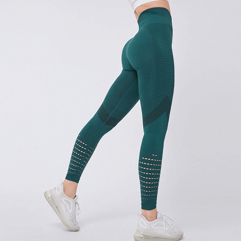 Women's teal hollow seamless high-waisted fitness leggings showcase a booty-lifting design and breathable fabric for comfort during exercise.